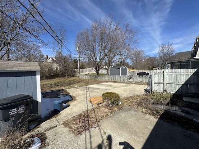 view of yard with a fenced backyard, a patio, an outdoor structure, and a shed