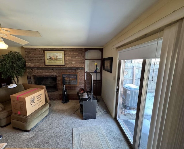 living area with carpet flooring, ceiling fan, and a fireplace