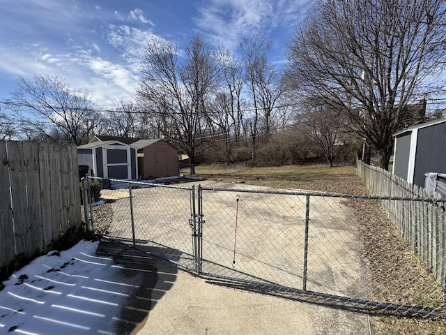 view of yard with a storage shed, a fenced backyard, and an outbuilding