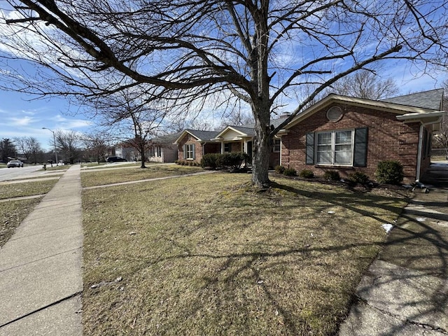 exterior space featuring brick siding and a front lawn