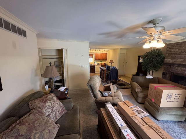 living area featuring visible vents, crown molding, ceiling fan, light colored carpet, and a fireplace