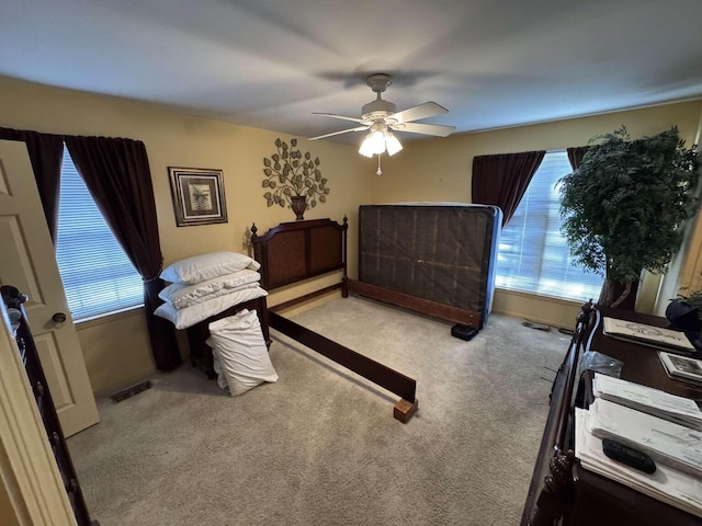 carpeted bedroom with visible vents and ceiling fan