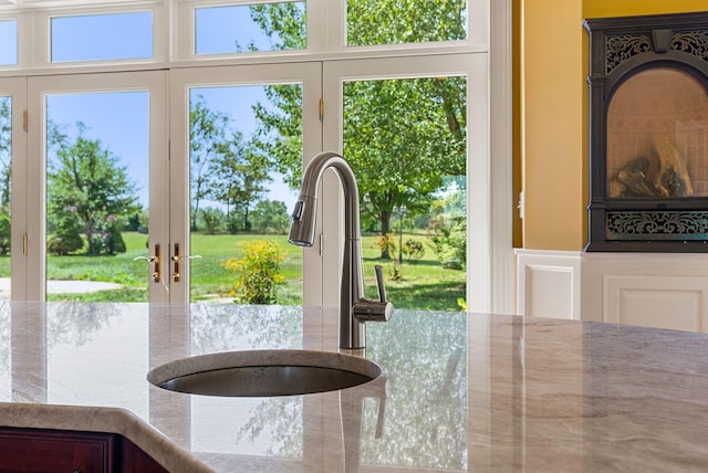 details with french doors, stone counters, and a sink