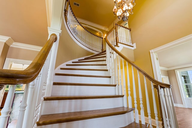 stairs with visible vents, baseboards, an inviting chandelier, and ornamental molding