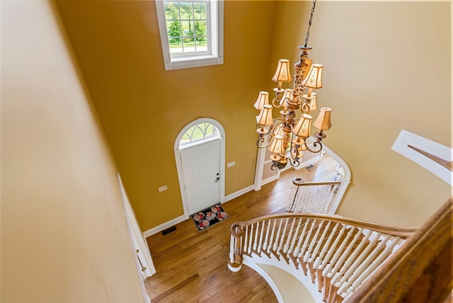 foyer featuring visible vents, wood finished floors, baseboards, and a chandelier