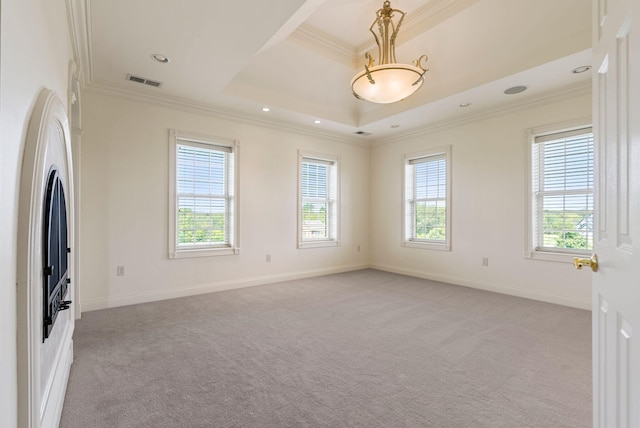 empty room with visible vents, light colored carpet, a healthy amount of sunlight, and ornamental molding