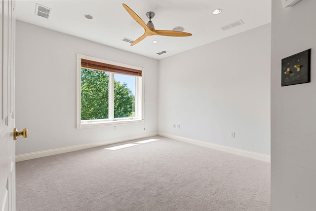 carpeted spare room featuring visible vents and baseboards