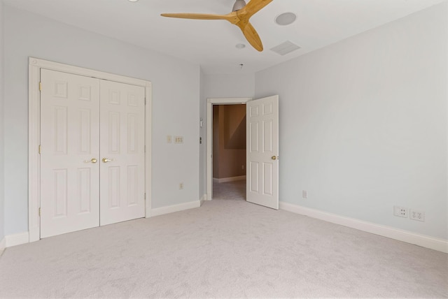 unfurnished bedroom with baseboards, a closet, and light carpet