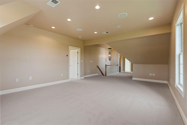 additional living space with visible vents, lofted ceiling, and baseboards