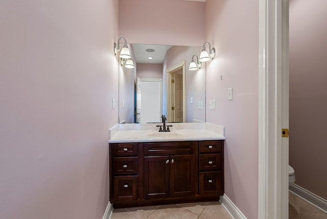 bathroom featuring tile patterned flooring, toilet, vanity, and baseboards