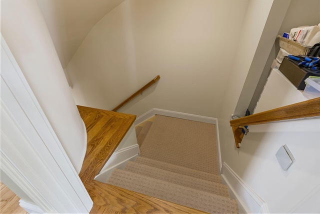 stairway featuring wood finished floors and baseboards