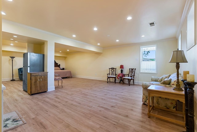 sitting room featuring light wood-type flooring, baseboards, and ornamental molding