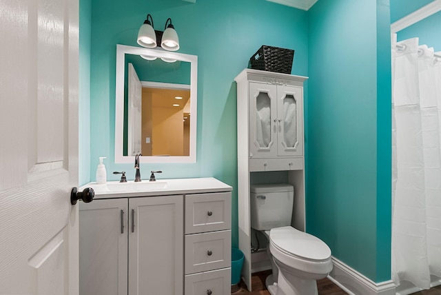 bathroom with vanity, wood finished floors, baseboards, curtained shower, and toilet