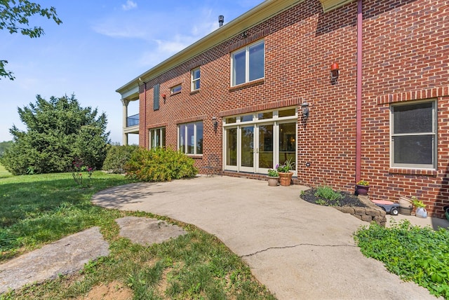 back of property with brick siding, a patio area, and french doors