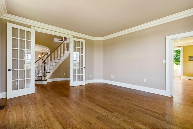 spare room featuring baseboards, stairs, ornamental molding, french doors, and wood finished floors