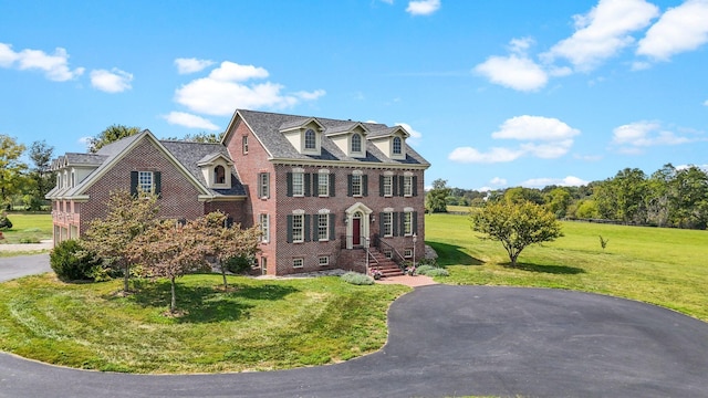 colonial house featuring a front yard and brick siding