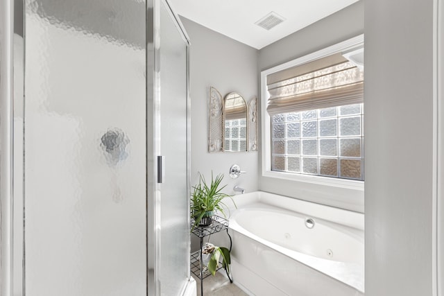 bathroom with a shower stall, a tub with jets, and visible vents