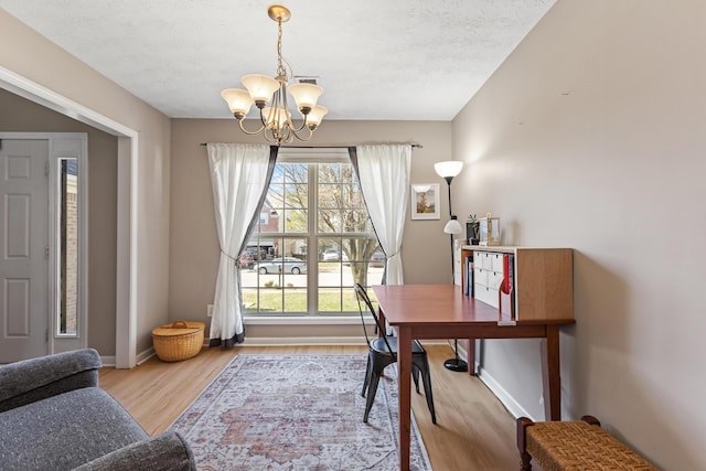 office with an inviting chandelier, wood finished floors, a healthy amount of sunlight, and baseboards