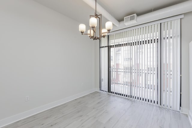 empty room with light wood-type flooring, visible vents, baseboards, and an inviting chandelier