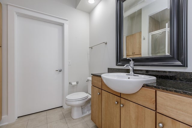 full bathroom featuring tile patterned floors, a shower with shower door, toilet, and vanity