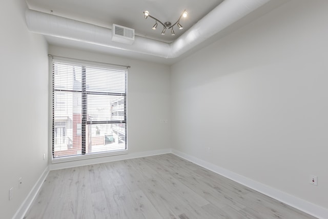 unfurnished room featuring visible vents, baseboards, and light wood finished floors