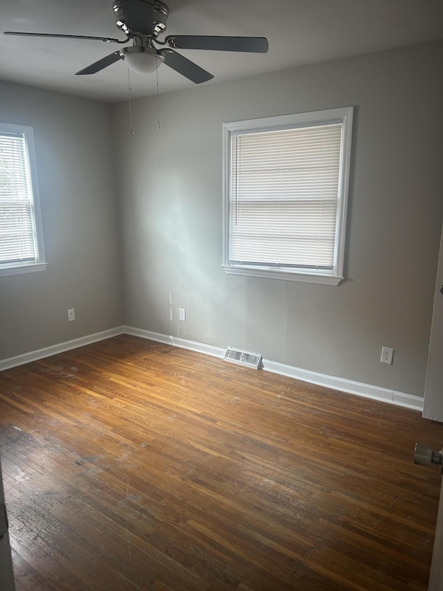 unfurnished room featuring visible vents, wood-type flooring, baseboards, and a ceiling fan