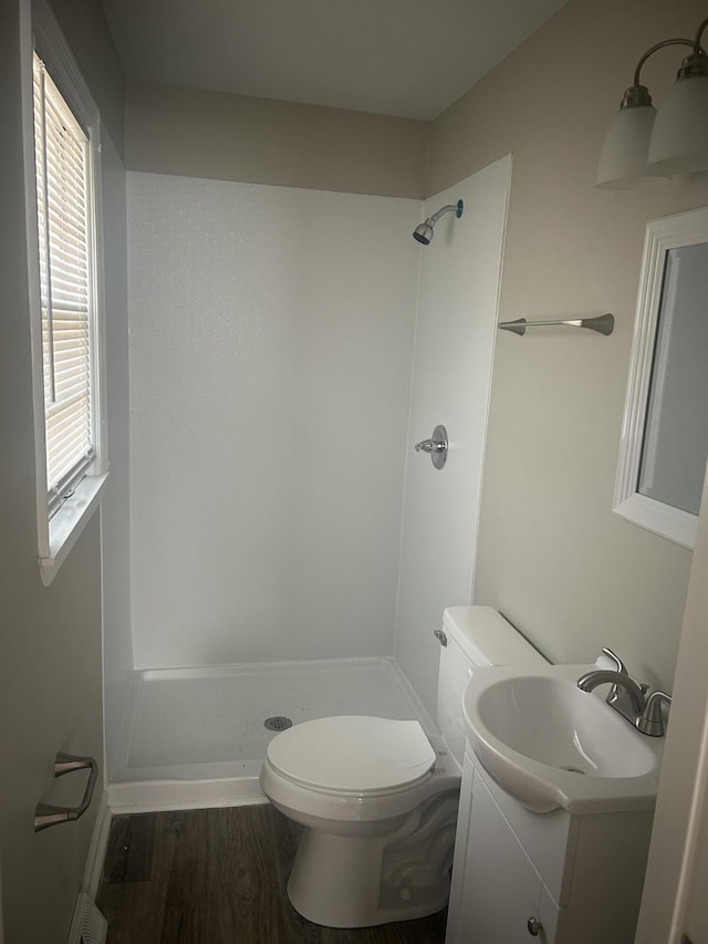 full bathroom with vanity, wood finished floors, visible vents, a stall shower, and toilet