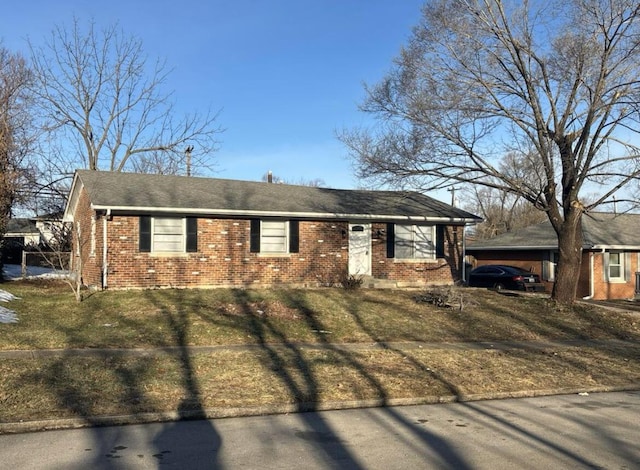 ranch-style home featuring brick siding and a front lawn