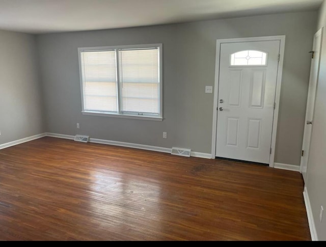 foyer entrance with visible vents, baseboards, and dark wood-style flooring