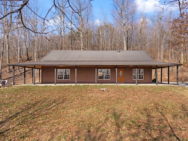 view of front of home with a patio, an attached carport, a front lawn, and metal roof