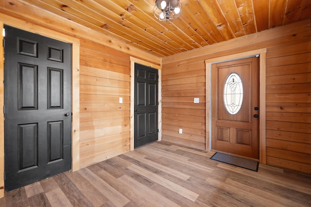 entrance foyer with wood finished floors, wooden walls, and wood ceiling