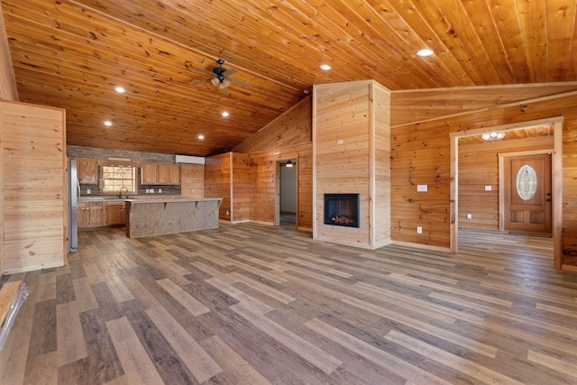 kitchen with dark wood-type flooring, open floor plan, freestanding refrigerator, wood walls, and wood ceiling