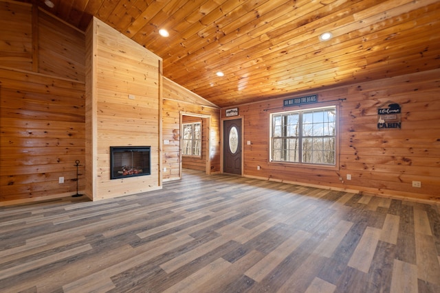 unfurnished living room featuring wood walls, wood ceiling, a fireplace, wood finished floors, and high vaulted ceiling