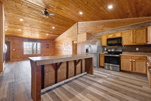 kitchen featuring stainless steel appliances, wooden walls, wood ceiling, and light wood-style flooring