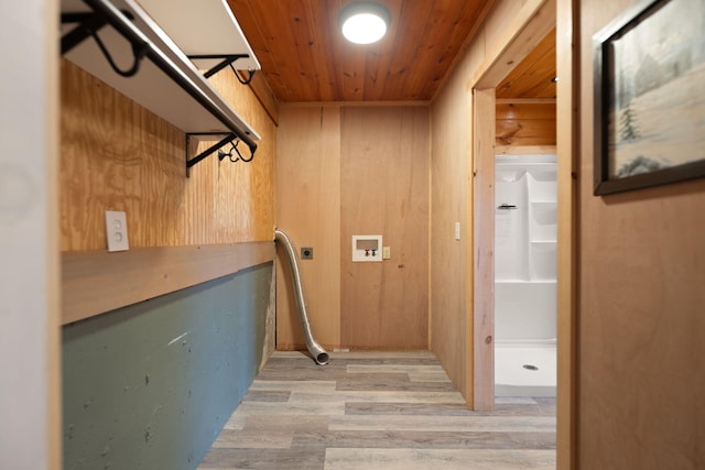 clothes washing area with light wood-style floors, wooden ceiling, laundry area, and wood walls