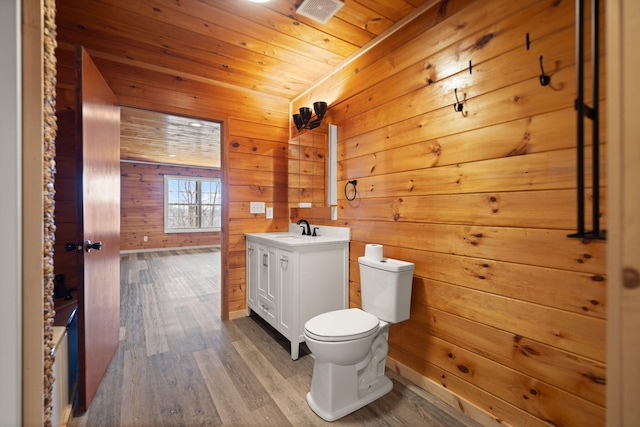 bathroom with wood finished floors, toilet, wooden ceiling, and vanity