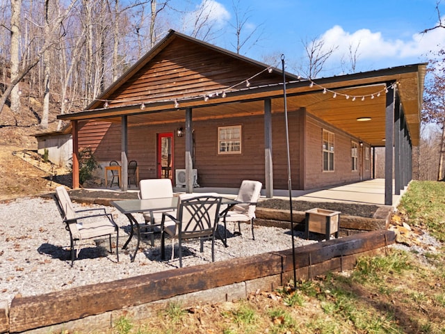 rear view of property with a patio and a carport