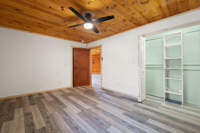 unfurnished bedroom with wood finished floors, a closet, wooden ceiling, baseboards, and ceiling fan