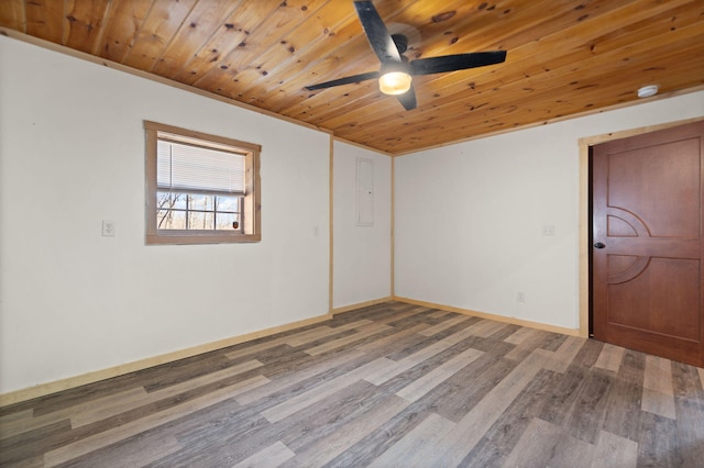 spare room featuring wood finished floors, wood ceiling, baseboards, and ceiling fan