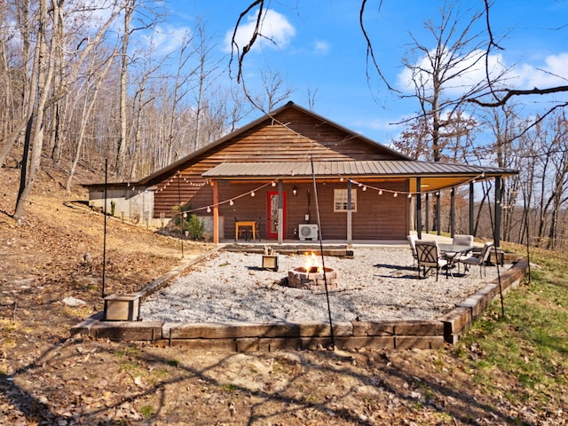 exterior space featuring metal roof, a patio, and a fire pit