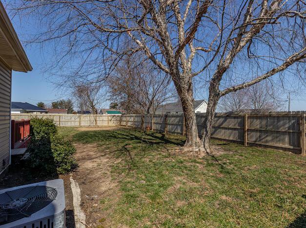 view of yard with central air condition unit and a fenced backyard