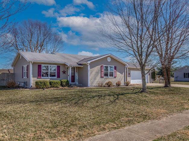 ranch-style home featuring a front yard, an attached garage, and fence