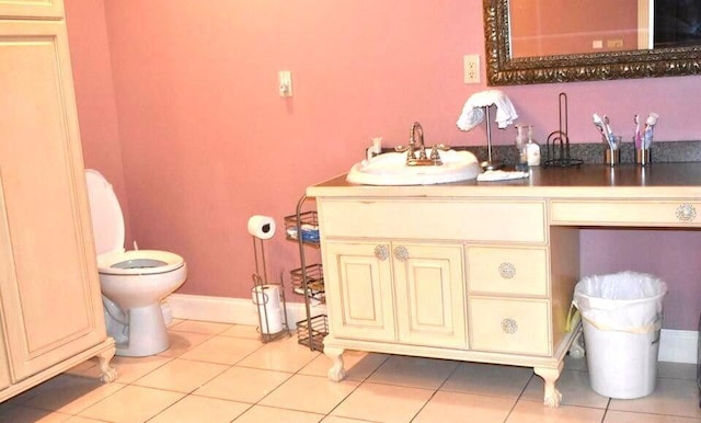 bathroom featuring baseboards, toilet, vanity, and tile patterned flooring