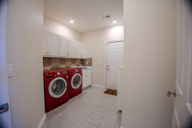 laundry room with baseboards, recessed lighting, separate washer and dryer, cabinet space, and a sink