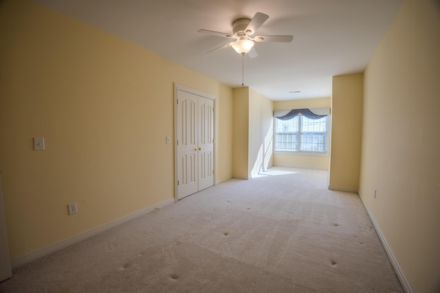 empty room featuring ceiling fan, baseboards, and carpet