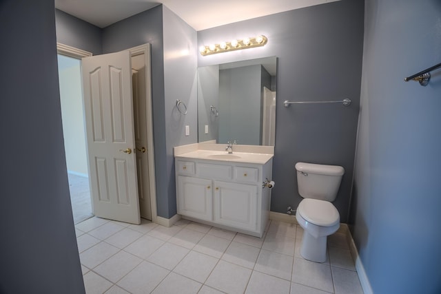 bathroom featuring baseboards, toilet, vanity, and tile patterned flooring