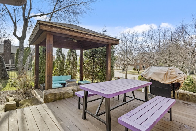 deck featuring a gazebo, outdoor dining area, a fire pit, and area for grilling