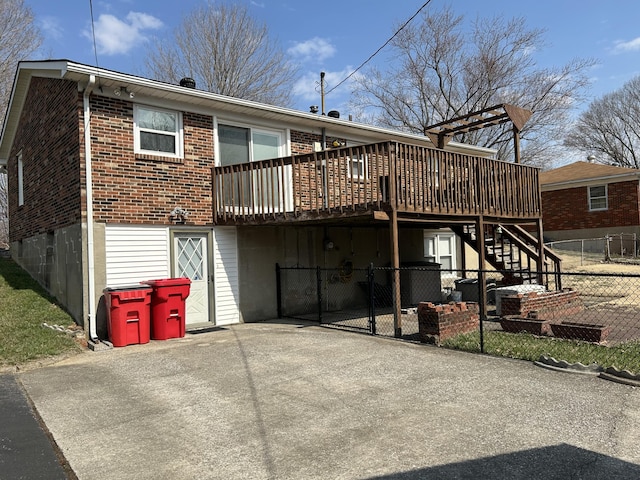 back of property featuring a wooden deck, brick siding, stairs, and fence