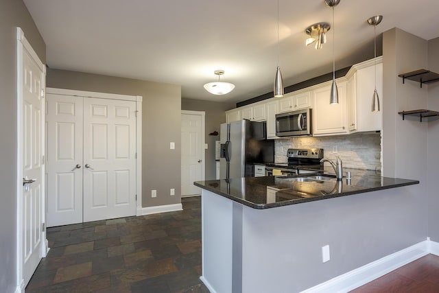 kitchen with baseboards, a peninsula, stainless steel appliances, decorative backsplash, and stone finish flooring