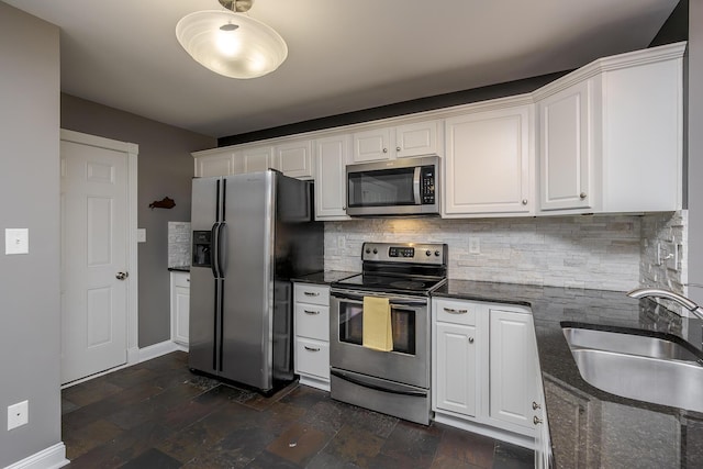 kitchen with white cabinets, tasteful backsplash, appliances with stainless steel finishes, and a sink